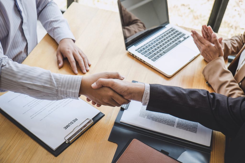 Greeting new colleagues, Handshake while job interviewing, male candidate shaking hands with Interviewer or employer after a job interview, employment and recruitment concept